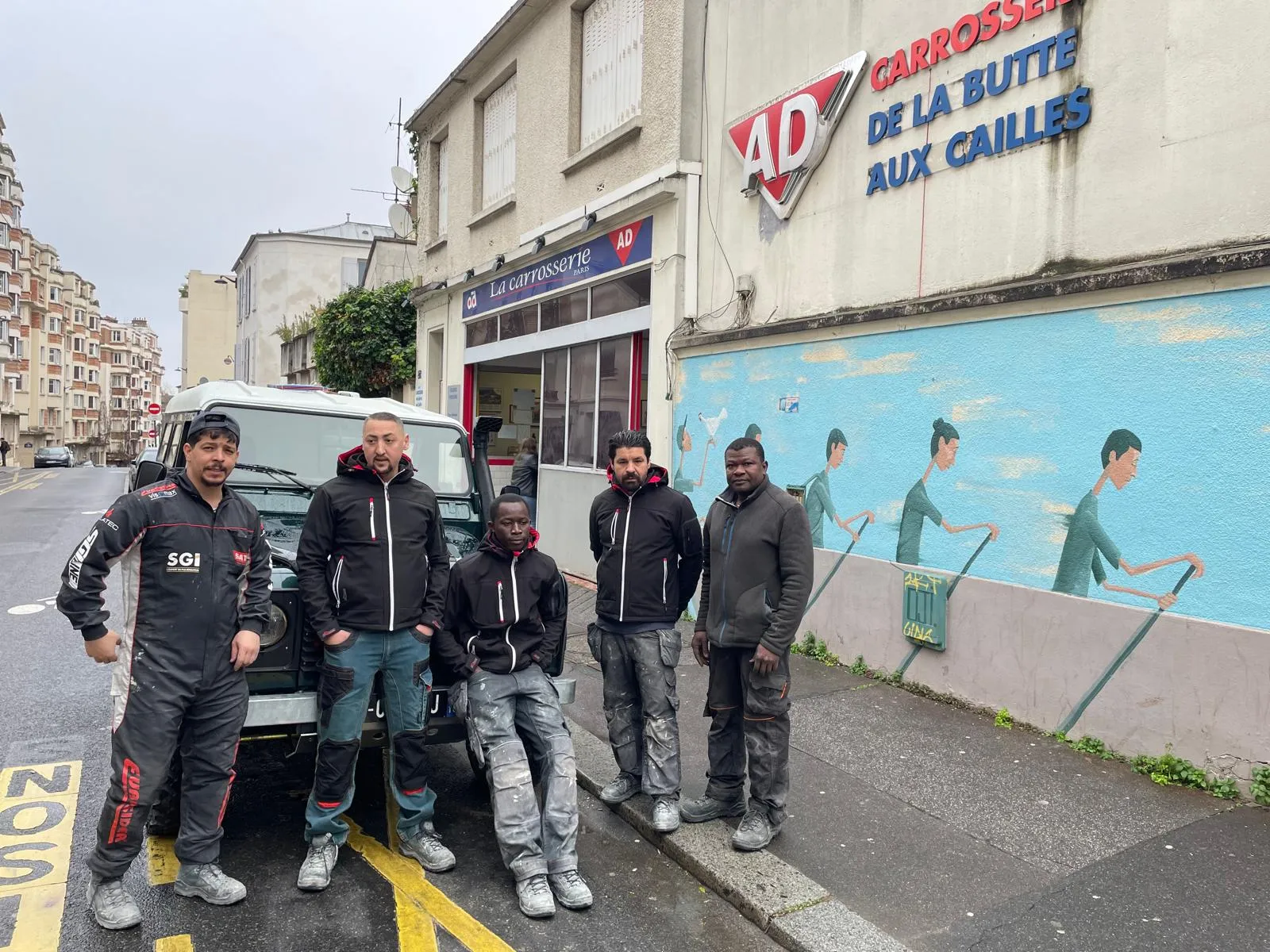 The team in front of the rue Barrault workshop, under the AD sign.
